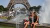 Женщины освежаются у фонтанов Трокадеро рядом с Эйфелевой башней в Париже
