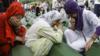 Боснийские мусульманки плачут над гробами убитых в Сребренице