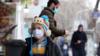 Ребенок в маске идет по улице Тегерана 26 февраля 2020 года