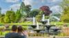 Вид на ботанический сад Кембриджского университета с фонтаном, стеклянным домом и людьми