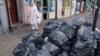 Женщина проходит мимо мешков с мусором в Алум-Рок, Бирмингем
