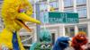 Большая Птица (L) и другие кукольные персонажи «Улицы Сезам» позируют рядом с временным уличным знаком 9 ноября 2009 г.