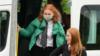 Ученик в маске выходит из школьного автобуса в Шотландии