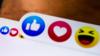 Снимок крупным планом, показывающий кнопки реакции Facebook, такие как, любить и смеяться на экране мобильного телефона