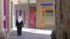 Мусульманка идет по узкой улочке в городке Лодев - коммуне в Эро на юге Франции