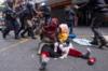 Женщина держится за своего ребенка во время столкновения полиции с иностранными гражданами, устроившими сидячую забастовку