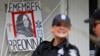 Офицеры стоят возле вывески с изображением Бренны Тейлор во время акции протеста в Сиэтле 1 июля 2020 года