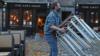 Работник паба складывает стулья в Эдинбурге