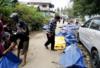 Местные жители проверяют сумки с телами, ища свои семьи на улице Палу