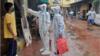 Медицинский персонал проверяет температуру жителя Мумбаи
