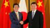 Премьер-министр Японии Синдзо Абэ (справа) пожимает руку президенту Китая Си Цзиньпину
