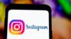 Логотип Instagram виден на экране мобильного телефона на фоне яркого, но размытого