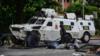 Автомобиль Национальной гвардии проезжает баррикаду, построенную антиправительственными активистами в третьем городе Венесуэлы, Валенсии, 6 августа 2016 г.