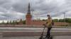 Мужчина в маске на скутере у Кремля в Москве