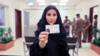 Женщина показывает свои саудовские водительские права