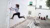 6-летний Килиан в защитной маске прыгает со скамейки после того, как ограничения для детей были частично сняты во время вспышки коронавирусной болезни (COVID-19) в Игуаладе, Испания, 26 апреля 2020 г.