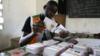 Сотрудник избирательной комиссии Кот-д'Ивуара держит карточки для голосования во время раздачи карточек для голосования в преддверии президентских выборов в стране, которые состоятся 31 октября 2020 года в Абиджане, Кот-д'Ивуар, 21 октября 2020 года.