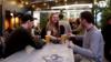 Клиенты наслаждаются напитками и обслуживанием столиков в баре в Окленде