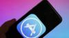 На фотографии показан логотип Apple App Store, отображаемый на iPhone на фоне сине-розового градиента