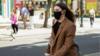 Женщина в маске идет по Оксфорд-стрит