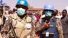 Члены миротворческой миссии Организации Объединенных Наций и Африканского союза (ЮНАМИД) наблюдают, как суданские внутренне перемещенные лица устраивают сидячую забастовку в знак протеста против истечения их мандата