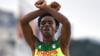 Эфиопская бегунья Фейиса Лилеса делает жест протеста оромо на Олимпийских играх