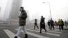 Люди в масках идут по задымленной улице Пекина