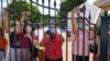 Посетители гонконгского Диснейленда в защитных масках фотографируются за забором.