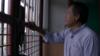 Али Фаузи смотрит сквозь решетку в тюрьме