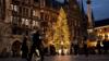 Люди проходят мимо рождественской елки, делая покупки на площади Мариенплац в Мюнхене, Германия, 15 декабря 2020 года