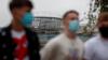 Студенты в масках проходят мимо здания Нортумбрийского университета