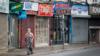 Женщина идет по улице Кардиффа с закрытыми магазинами позади