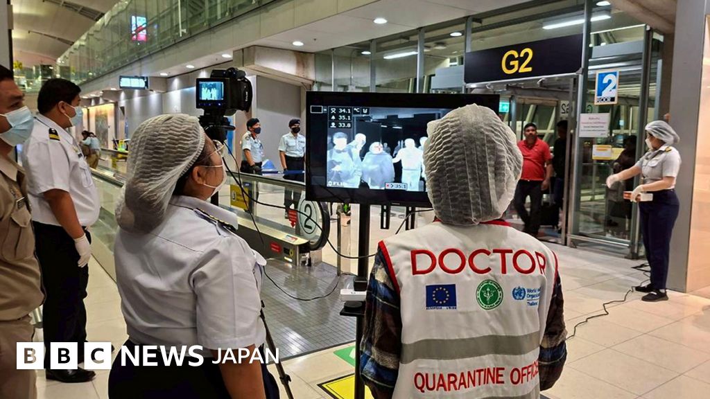 複数の空港職員が、モニターで空港利用者の体温を確認している。職員らはマスクをしているほか、女性は髪の毛をネットでまとめている。「医師、検疫官」と書かれたジャケットを着ている職員もいる