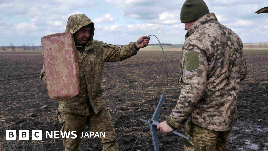 迷彩服を着た兵士2人が、平地にスターリンクの送受信機を設置しようとしている