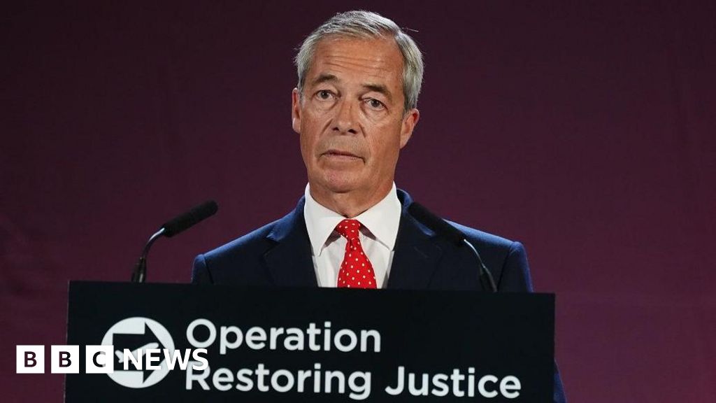 Nigel Farage, who has short grey hair parted to the side speaks at a podium with the words Operation Restoring Justice on it. He is wearing a dark suit, white shirt and red spotted tie.
