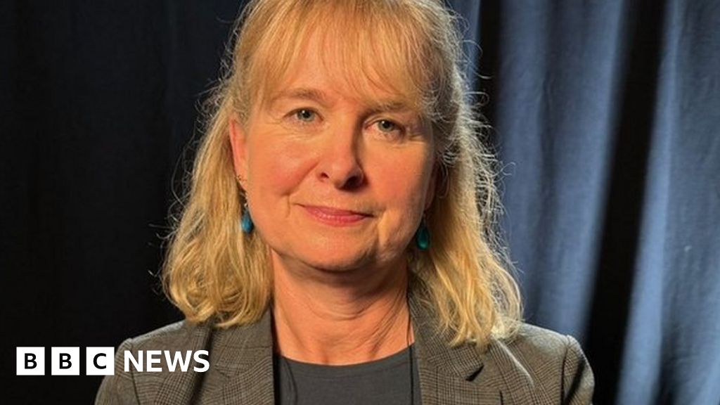 Celia Webster, a woman with light hair wearing a tweed jacket