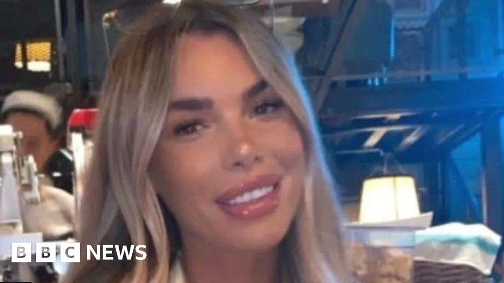 Blonde-haired Ashley Dale smiles for the camera at a restaurant