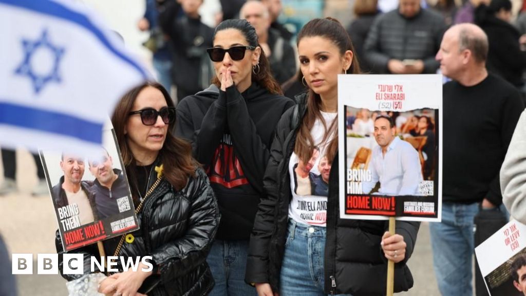 People in Tel Aviv holding placards with images of Israeli hostages (08/02/25)