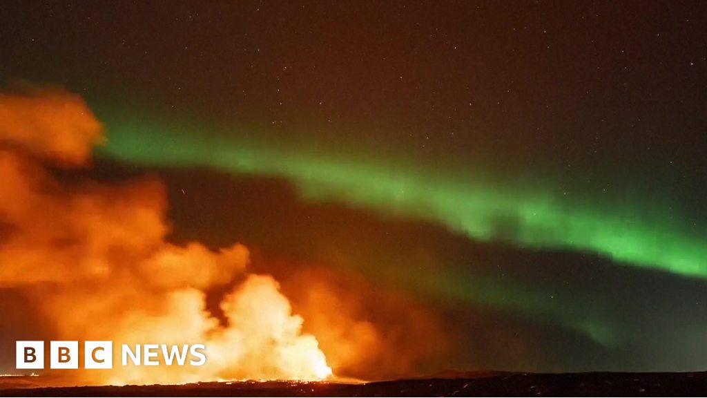 Northern Lights captured glowing over erupting volcano
