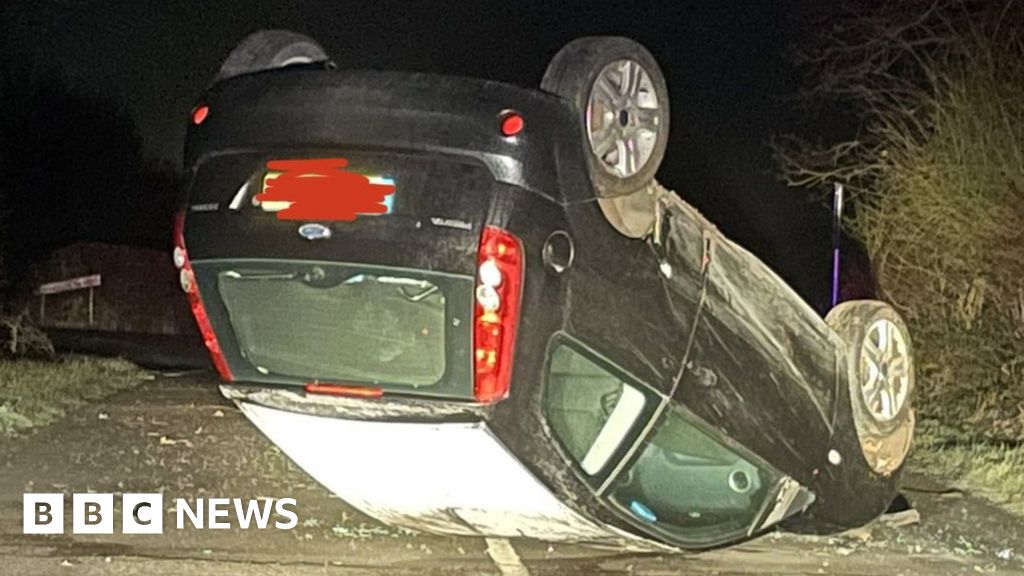 Car ends up on roof after skidding on icy Warwickshire road