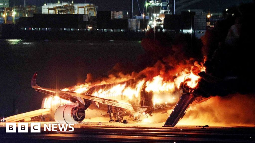 Разбити пътници до аварийните изходи на горящ самолет на Japan
