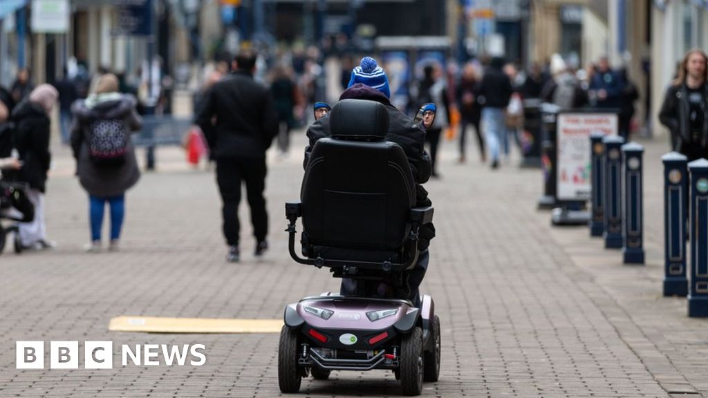 Person riding mobility scooter in public