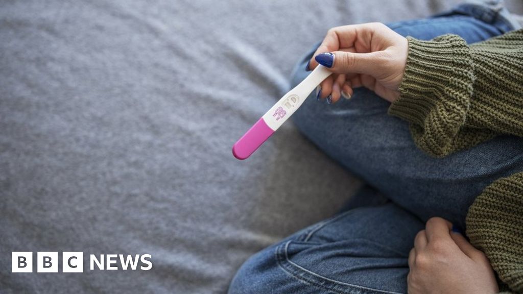 Unrecognisable woman holding positive pregnancy test.