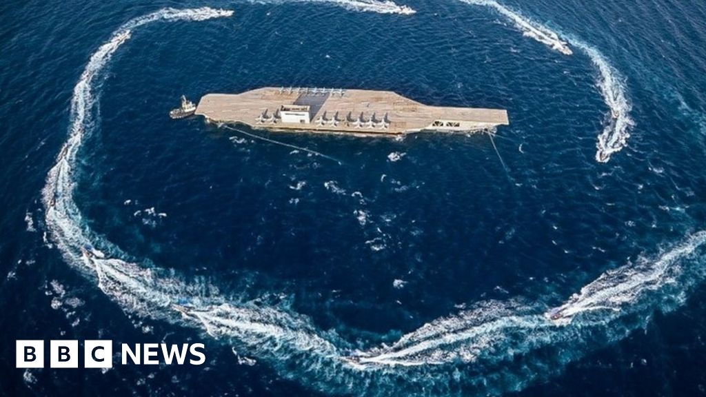 Iran blasts dummy US aircraft carrier with missiles - BBC News