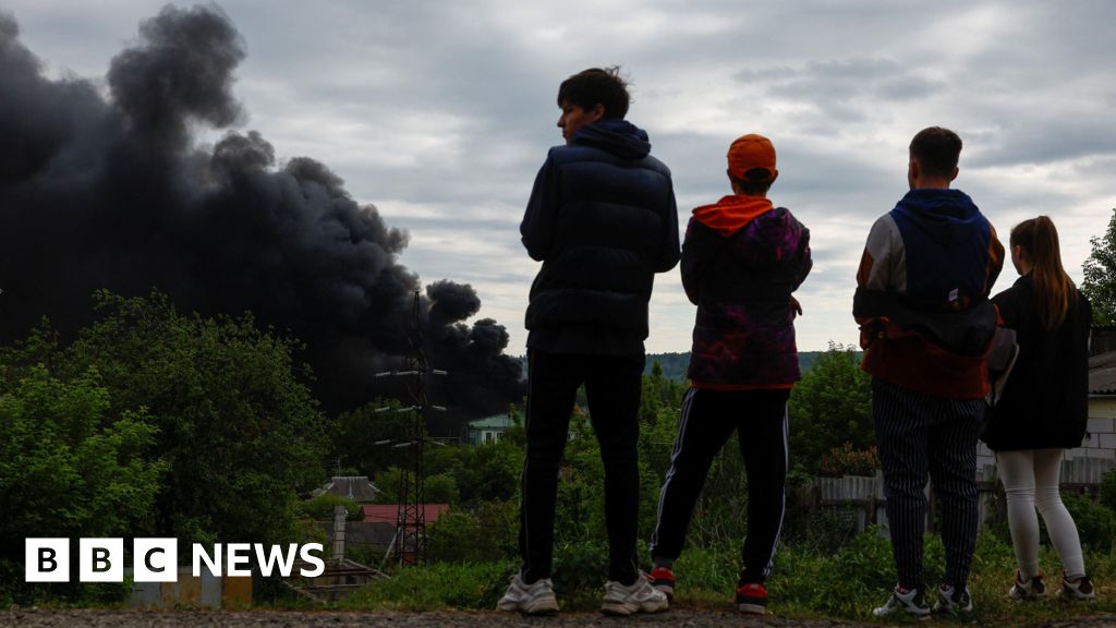 Teenagers look at smoke which rises after a Russian missile strike