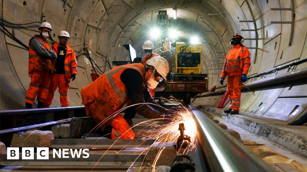Construction workers work on a section of train track inside a Crossrail tunnel, beneath Stepney in east London in 2016