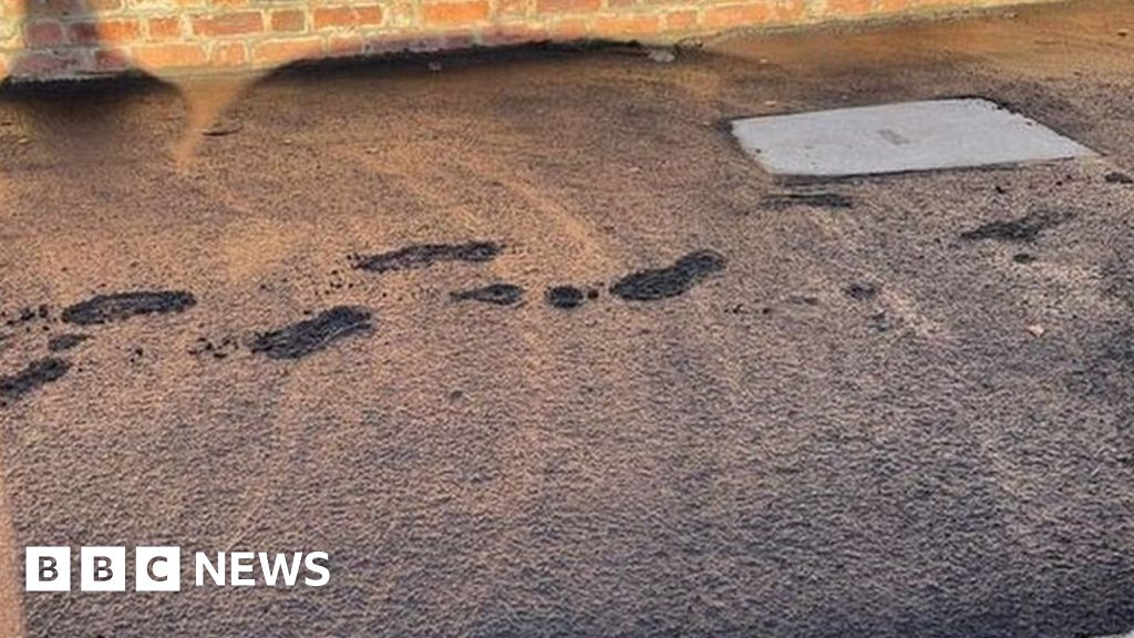 Footprints left in wet tar after workers fail to rope off pavement