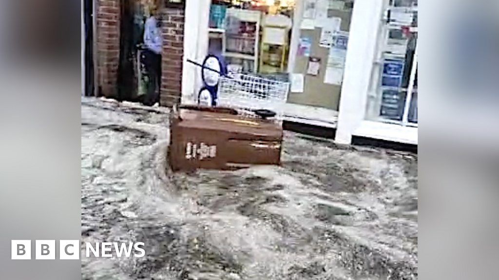 Shops flooded in Harpenden as torrent of water surges down street BBC