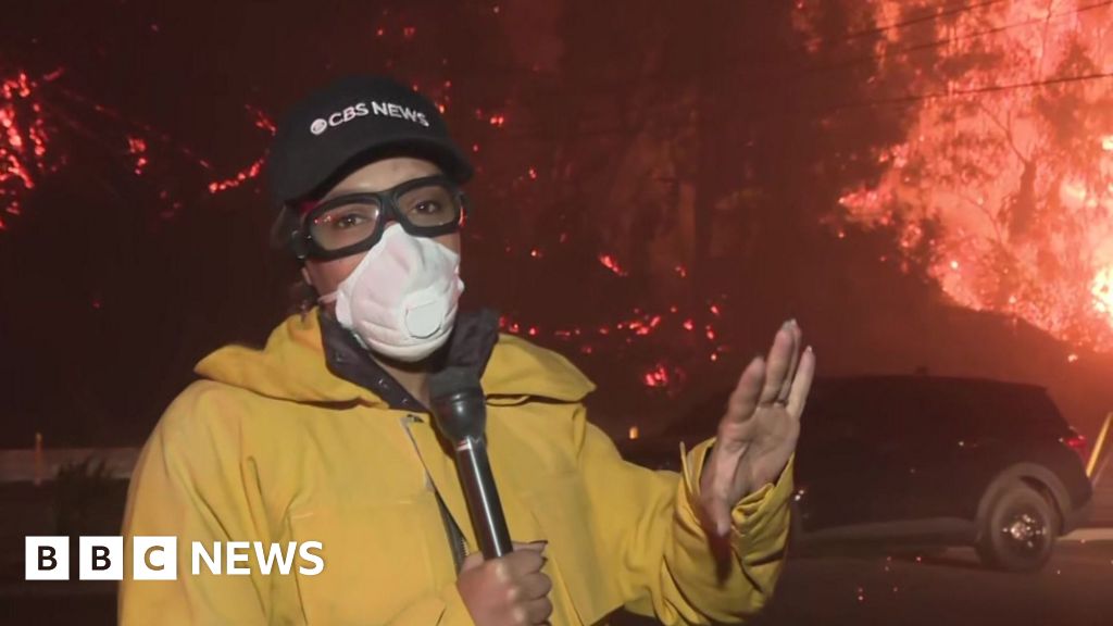 Ferocious LA fire burns behind CBS reporter