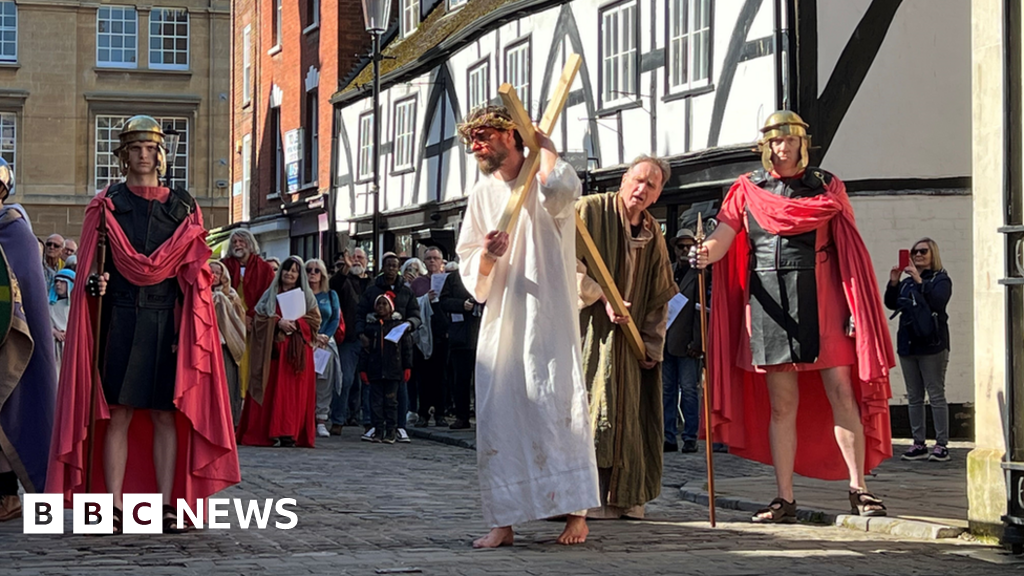 Re-enactment showing Jesus carrying a cross flanked by Roman soldiers